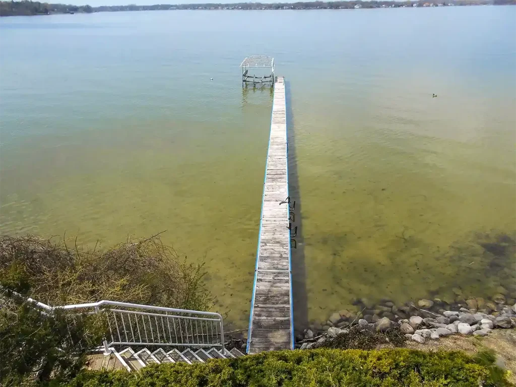 A very long seasonal dock in shallow water with boat lift